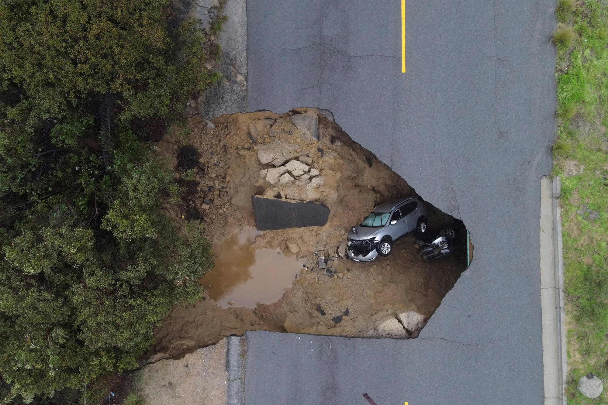 Giant Sinkhole Swallows Car In The Middle Of The Road In California