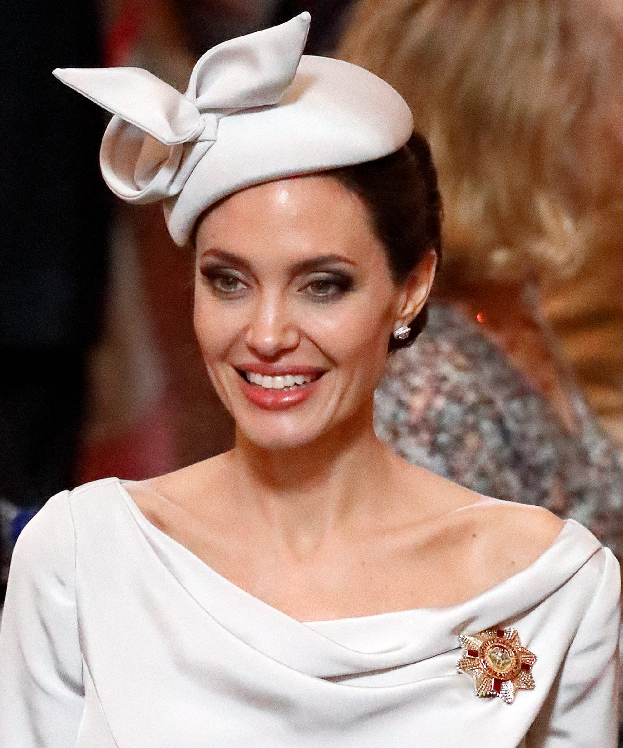 Angelina Jolie wearing a white dress and a white vintage hat