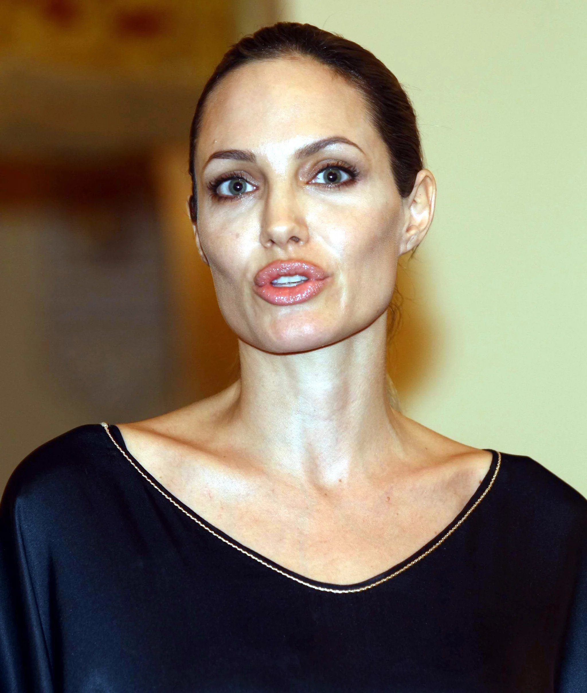 Angelina Jolie wearing a navy-blue dress with her hair tied in the form of a bun