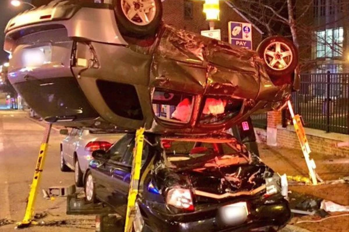A car crashed over another car on the road