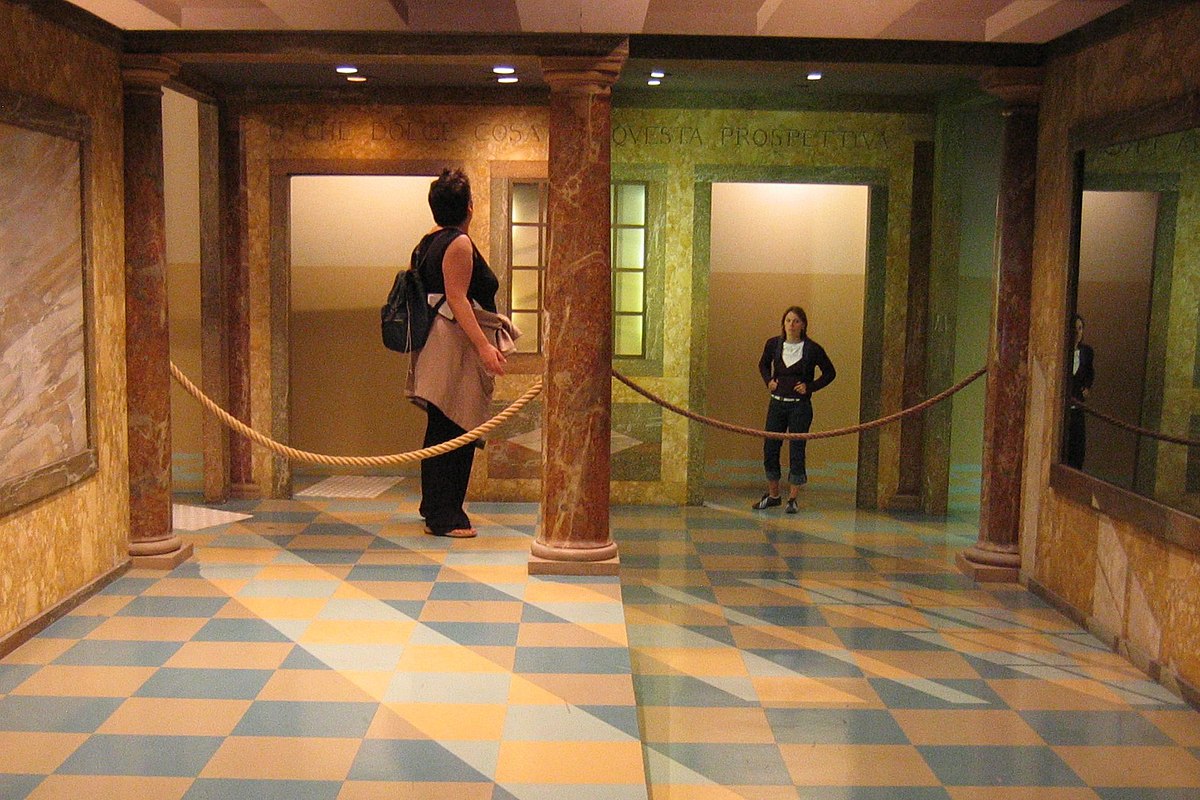 Two women standing in Ames Room