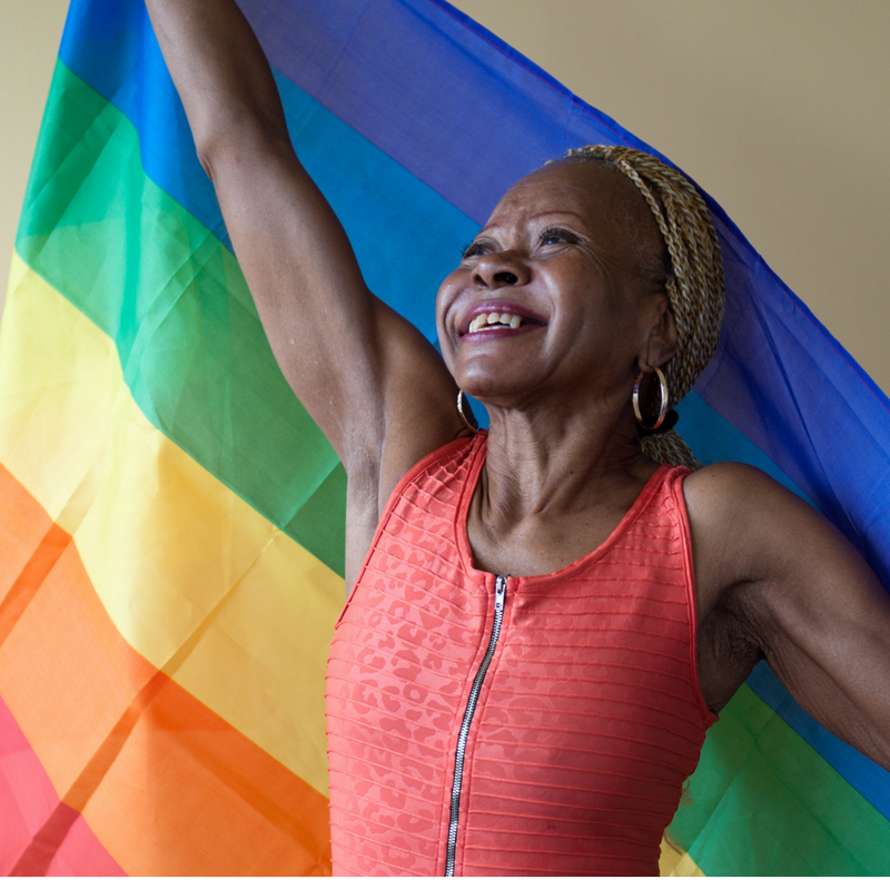 A Queer Woman Holding The Rainbow Flag