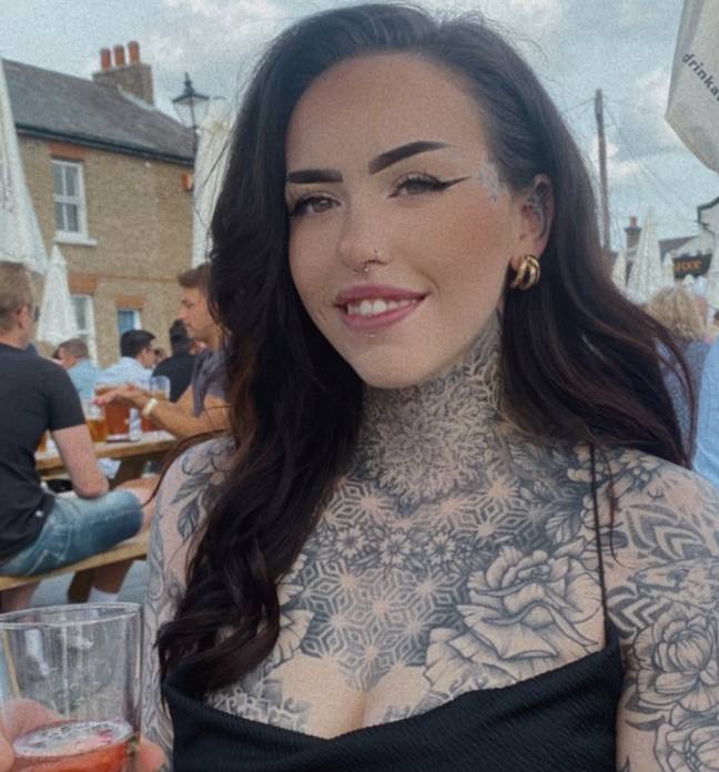Onlyfans creator Tegan-Leigh wearing a spaghetti strap black top and holding a drink in a glass