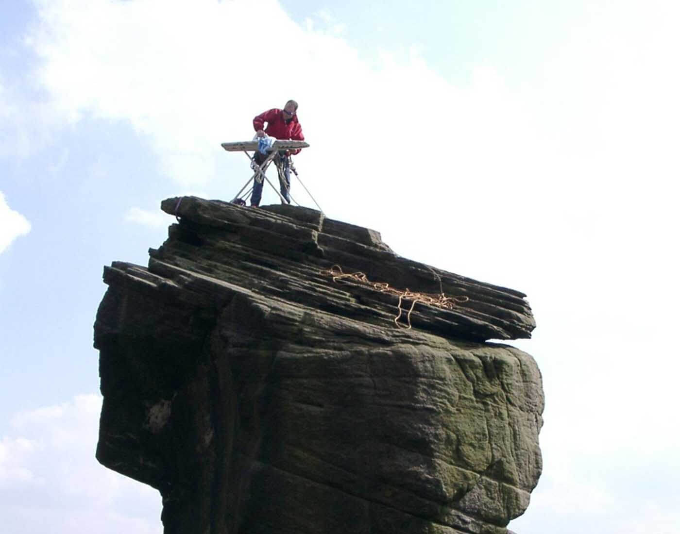 A person doing Extreme Ironing on the top of mountain
