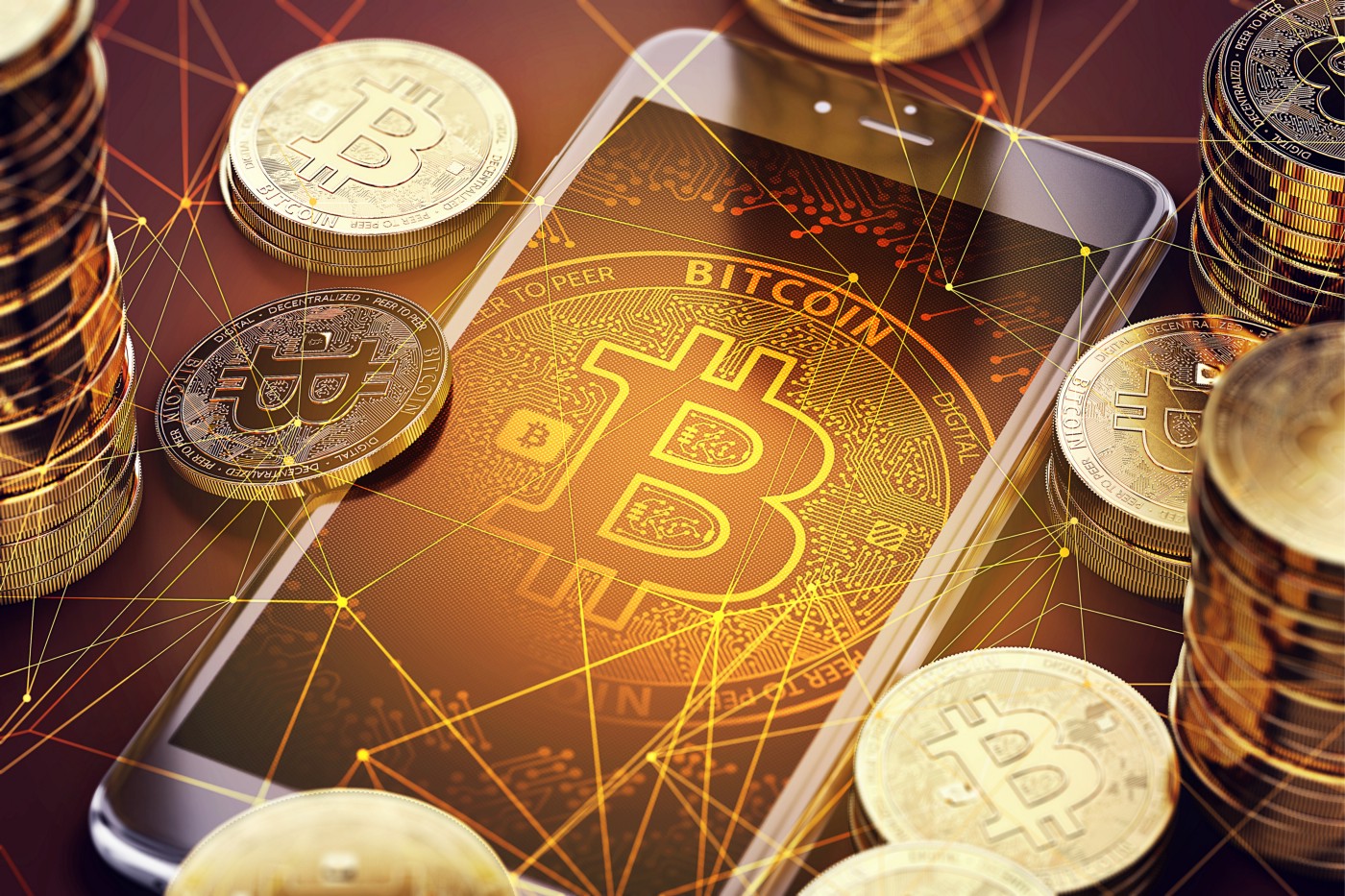 Bitcoin wallpaper on phone and stack of bitcoins around the phone