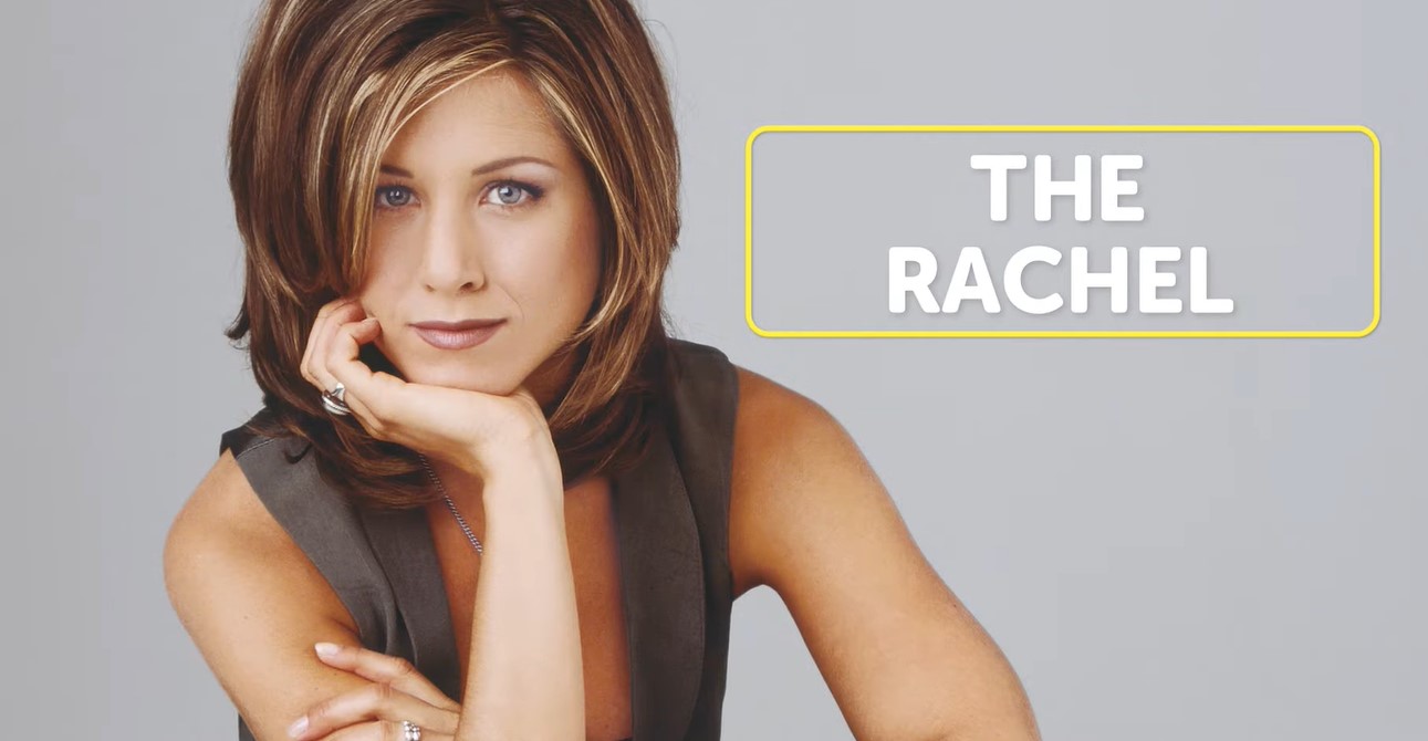 Jennifer Aniston in a sleeveless top and sporting the Rachel haircut, with chin resting on her right palm