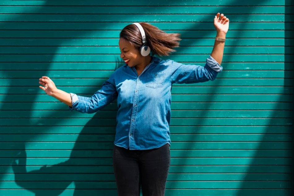 Woman dancing and smiling while listening to music