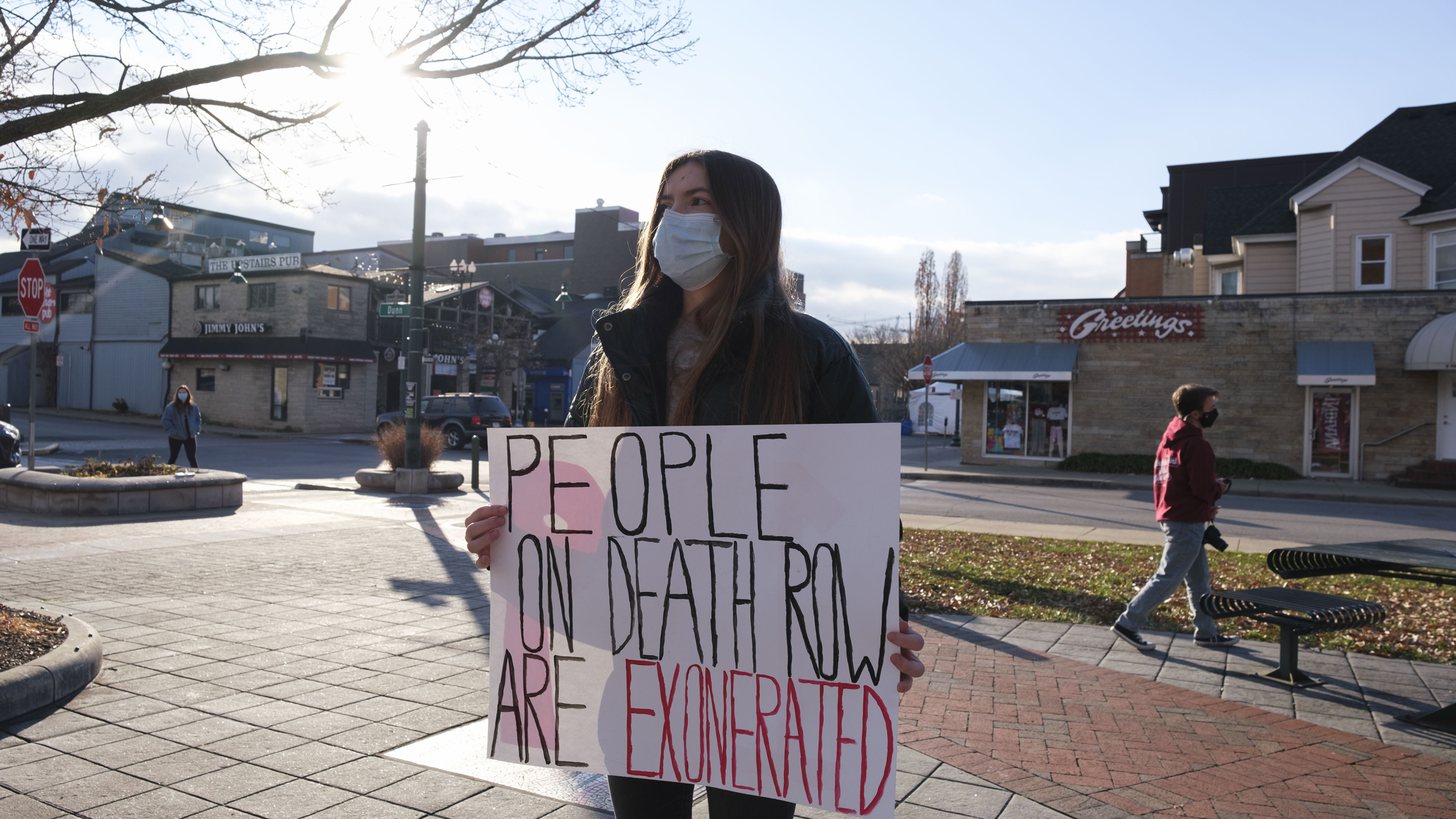 Woman Wearing A Facemask Holding People On Death Row Are Exonerated Sign