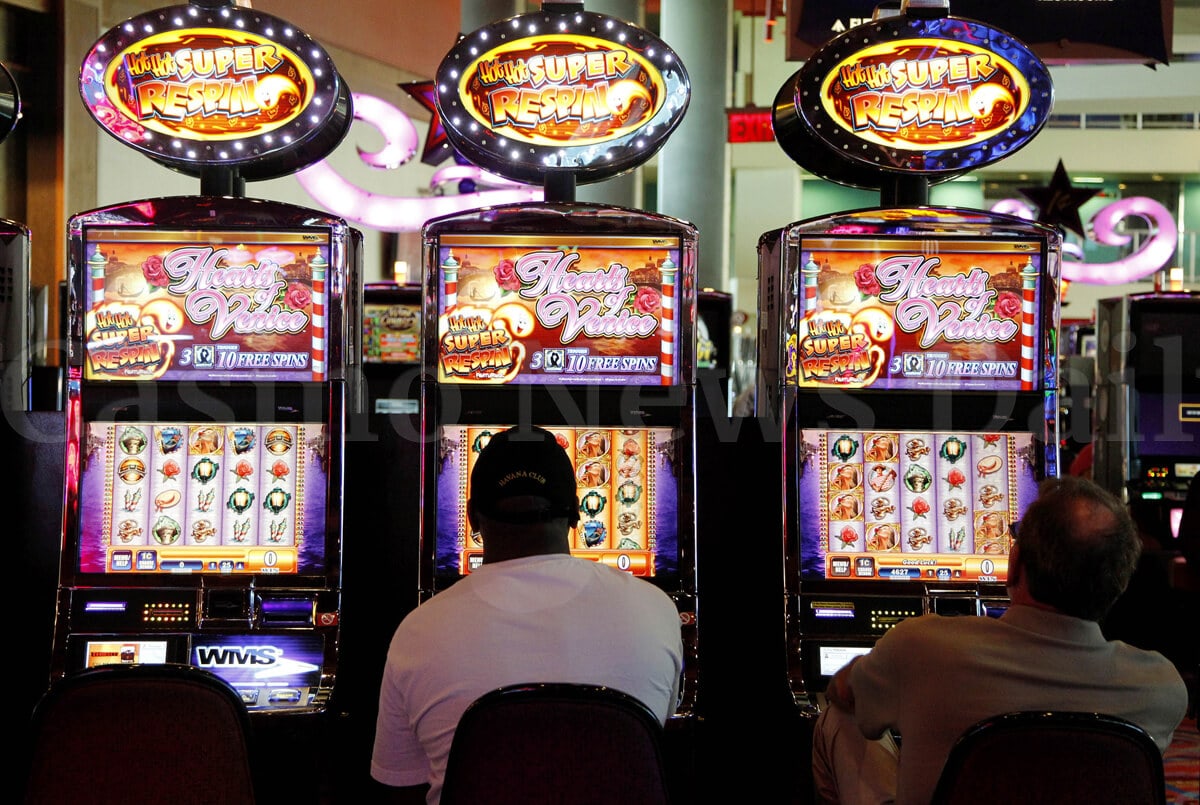 Two men playing slot machines in the casino