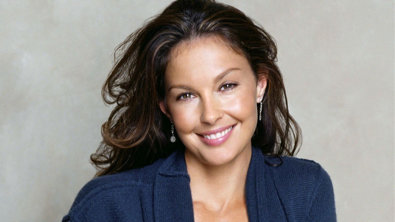Ashley Judd smiles at the camera while wearing earrings