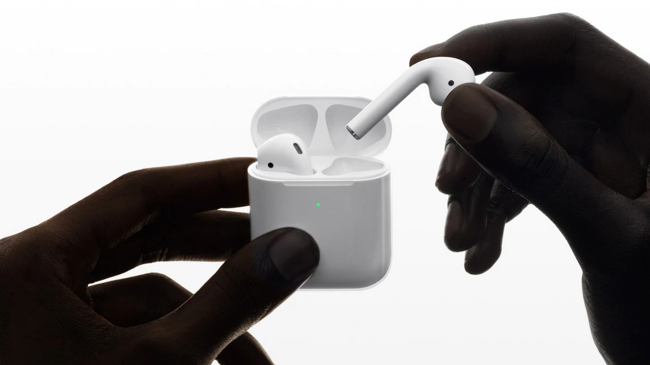 Hands holding Apple AirPods