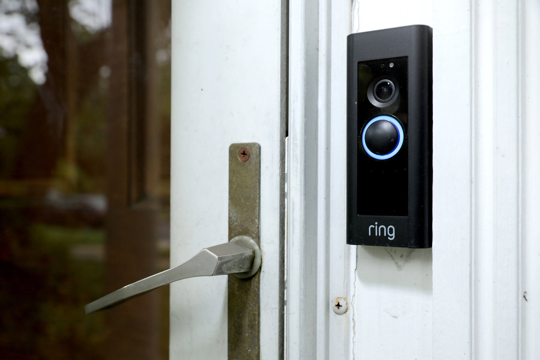 Black ring camera beside a door