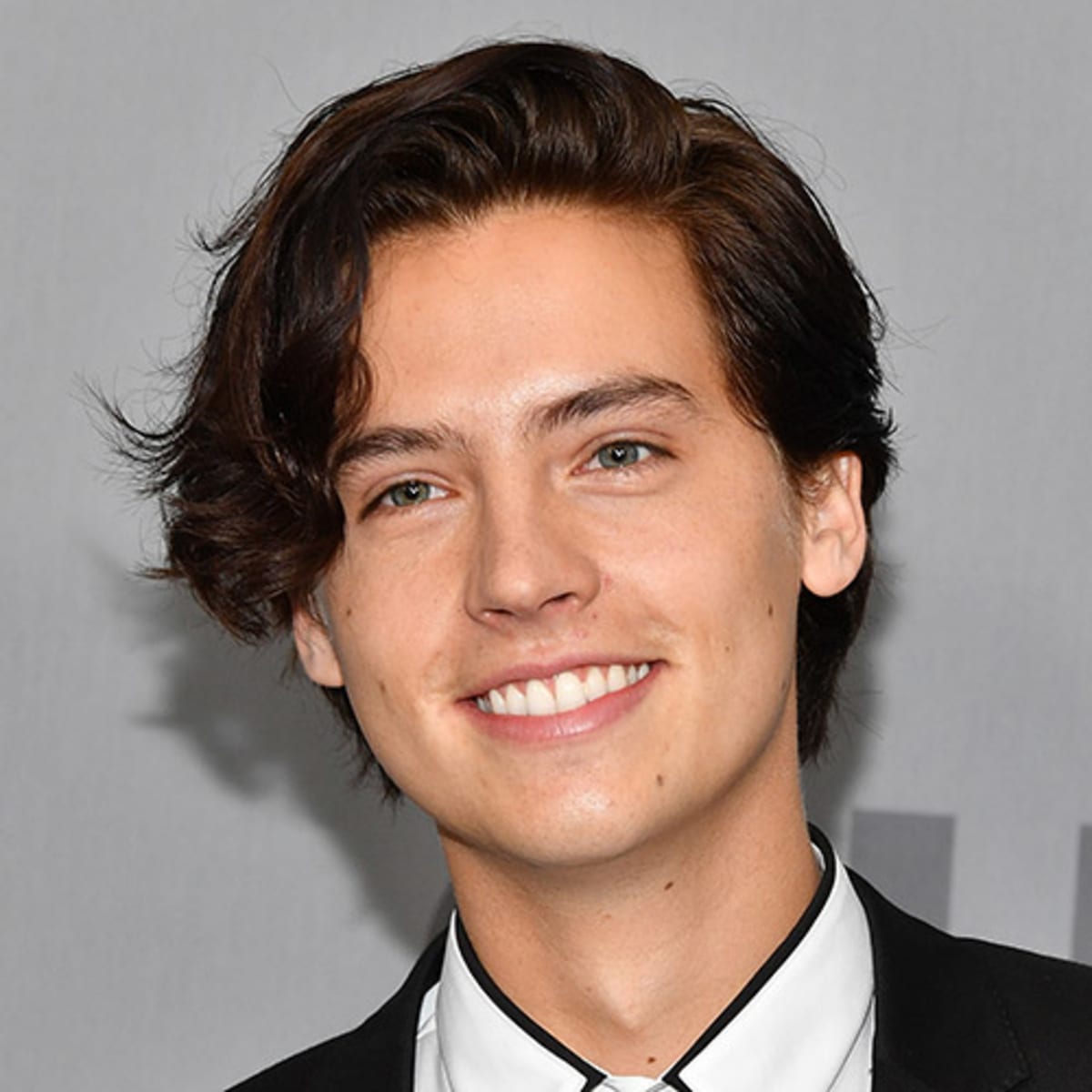 Cole Sprouse wearing a black and white suit and attending an event