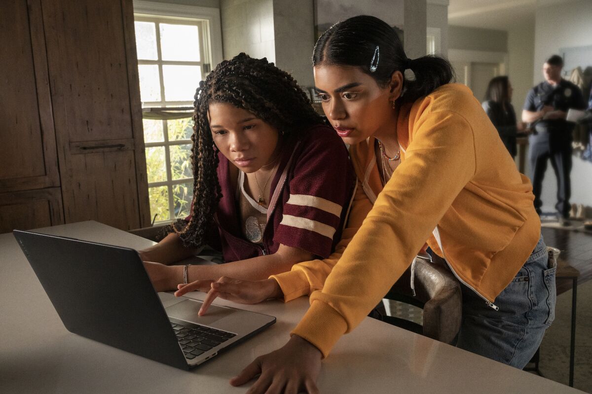 A scene from the Missing movie where two girls are watching something on laptop