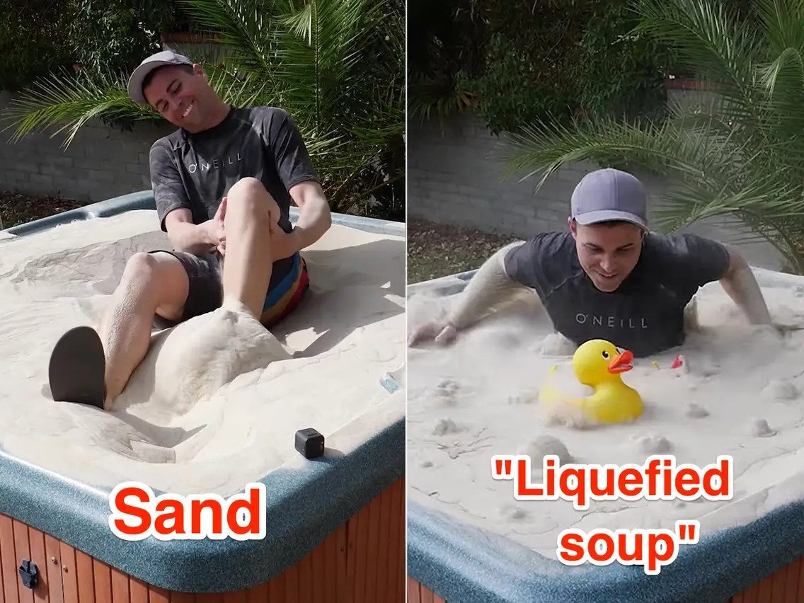 A man sitting or stuck in a sand pool; a man in a liquified sand pool with a yellow colored duck toy in pool