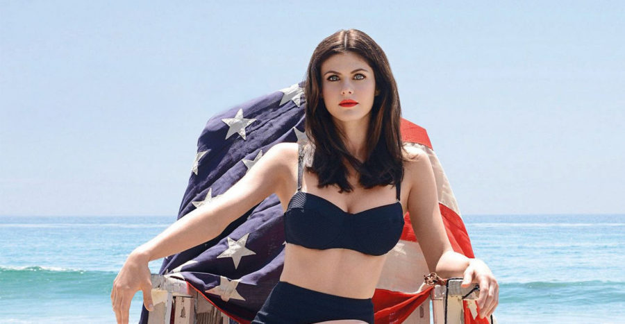 Alex daddario wearing sexy black top while sitting nearby the beach with the US flag behind her