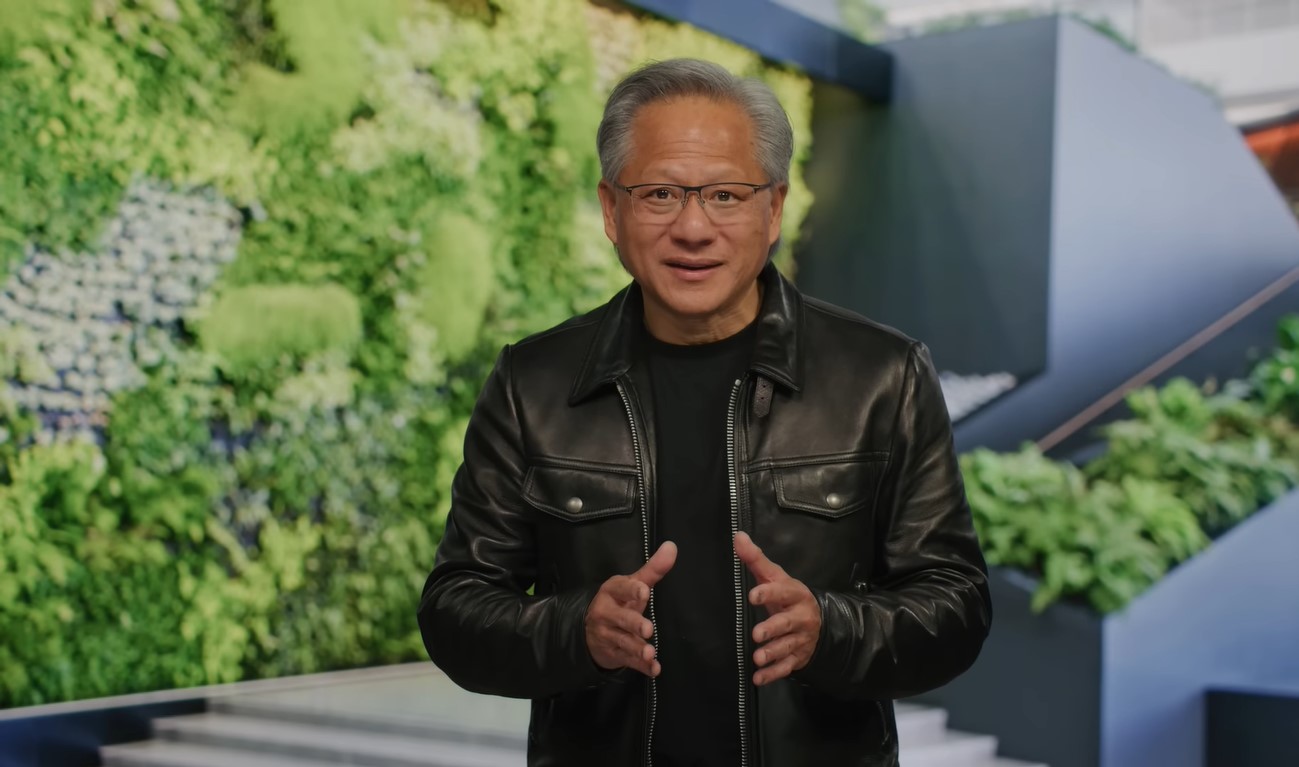 Nvidia CEO Jensen Huang in clear eyeglasses, black T-shirt and black leather jacket gesturing with his hands