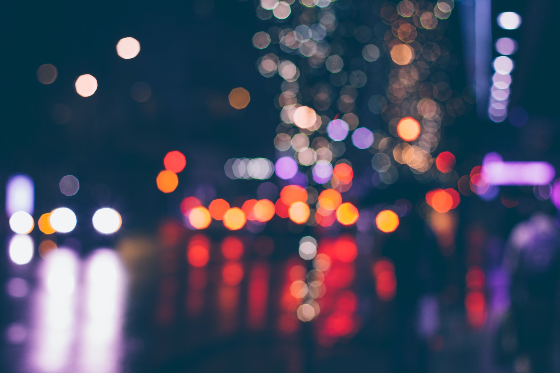 Bokeh effect of city lights and vehicles passing by the road at night