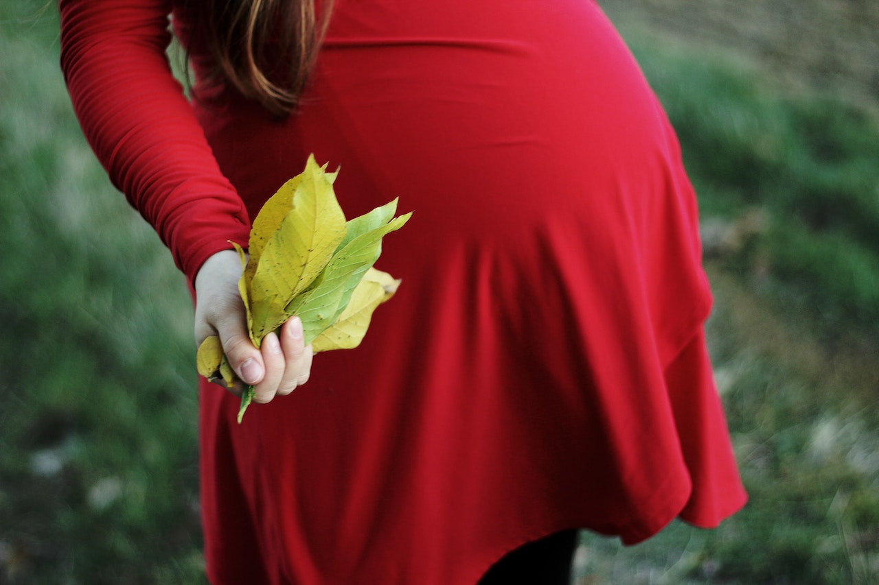 Pregnant Woman Holding Bundle of Leaves