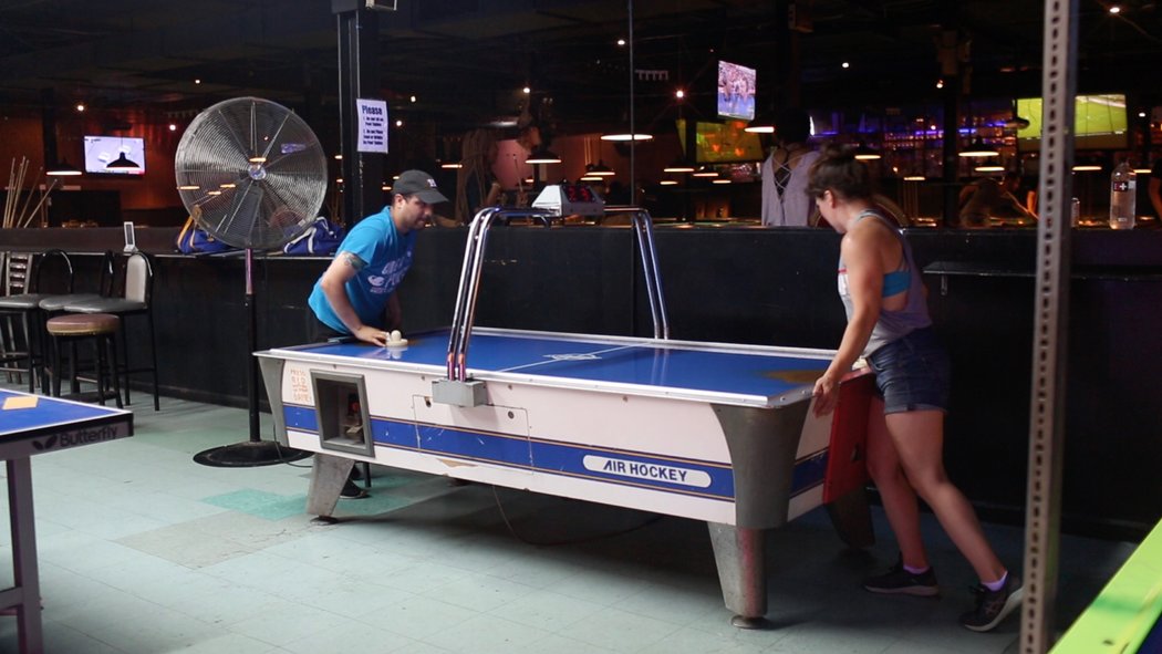 Two person playing on a Air Hockey table