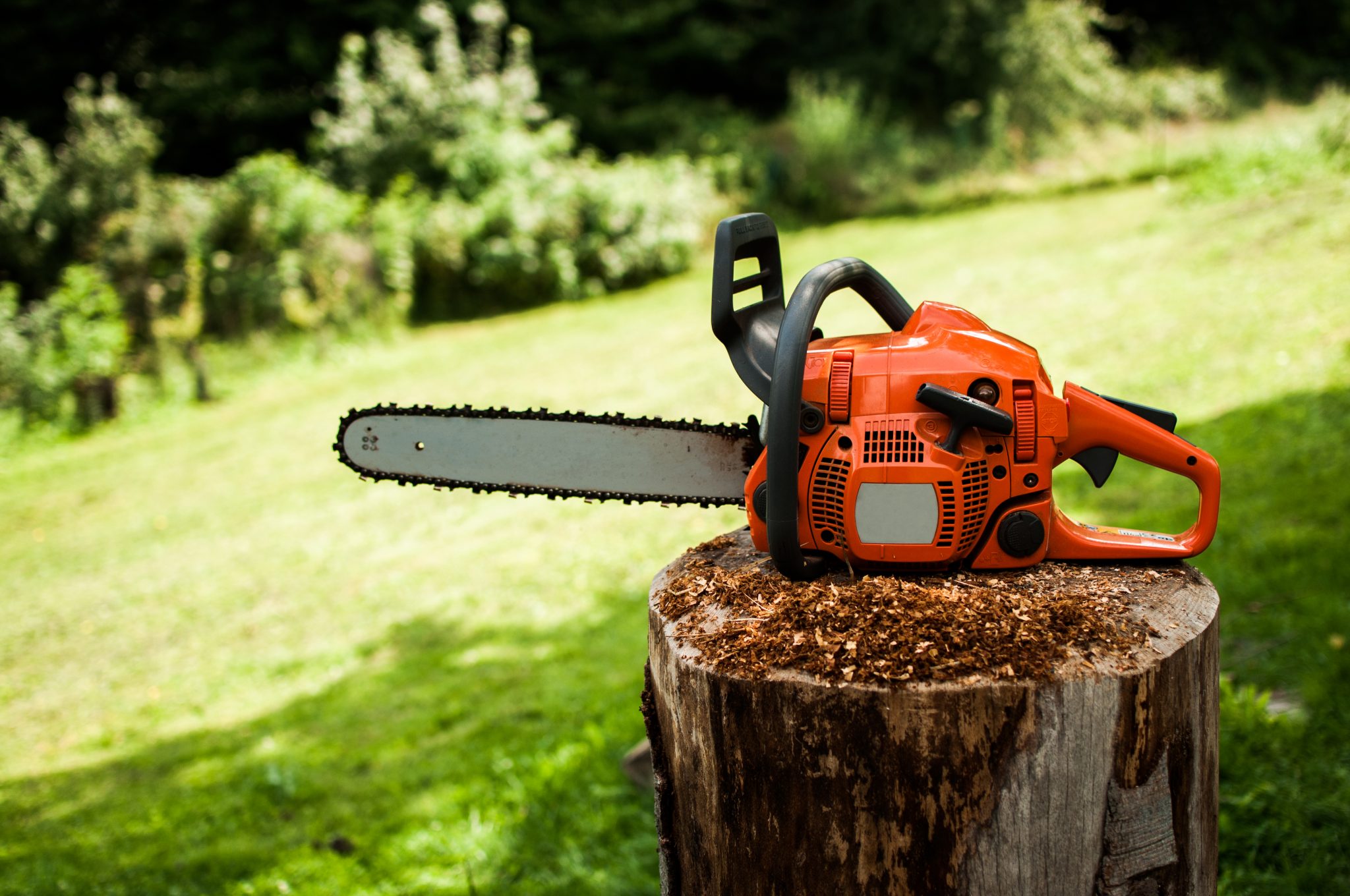 A chainsaw on a wooden stump.