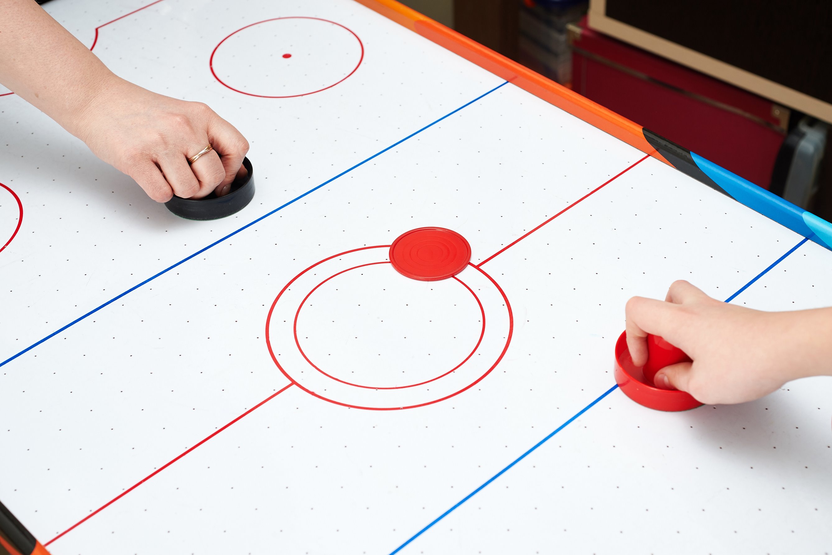 Close up of two hands playing air hockey