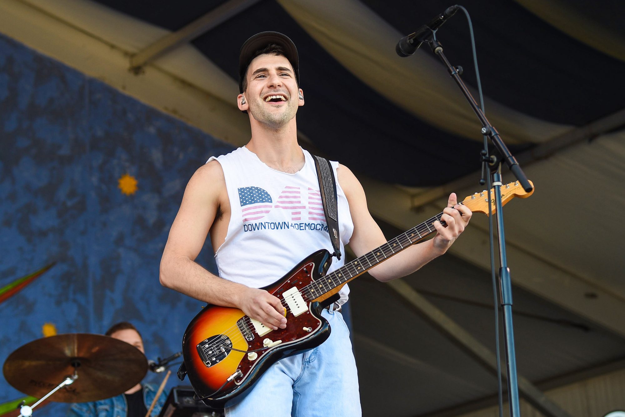 Jack Antonoff wearing a white tank top while playing electric guitar
