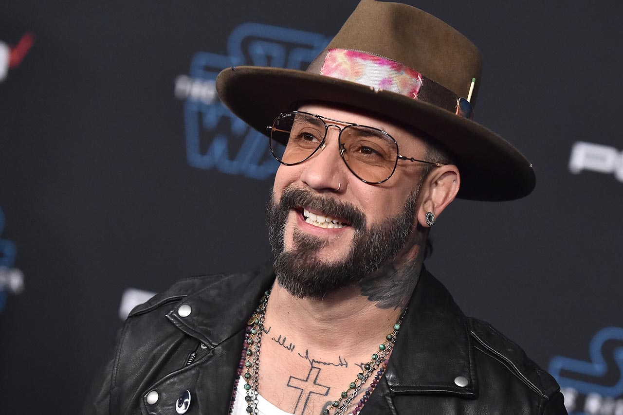 AJ McLean wearing a black leather jacket while wearing a brown fedora hat