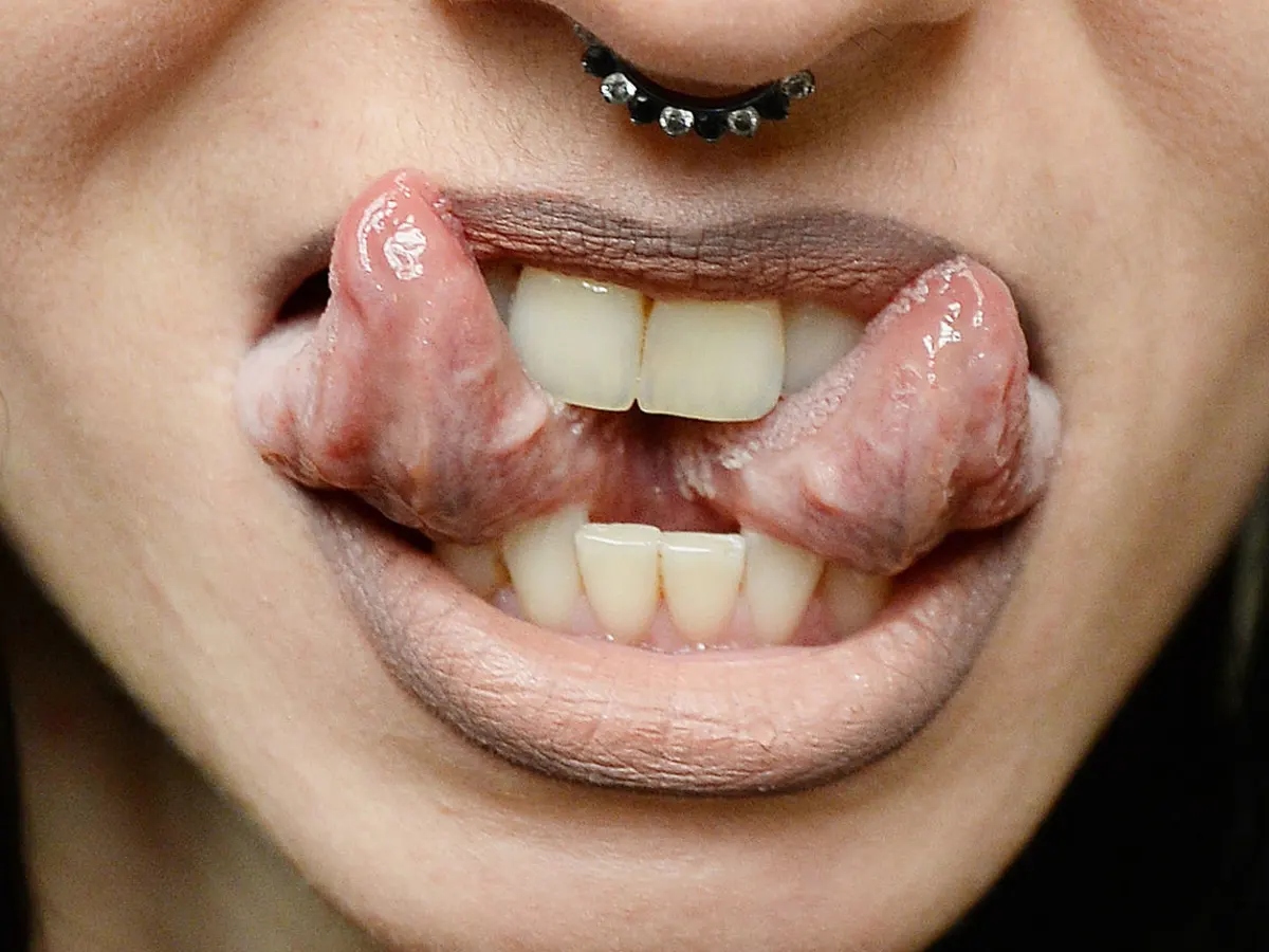 A woman showing her split tongue