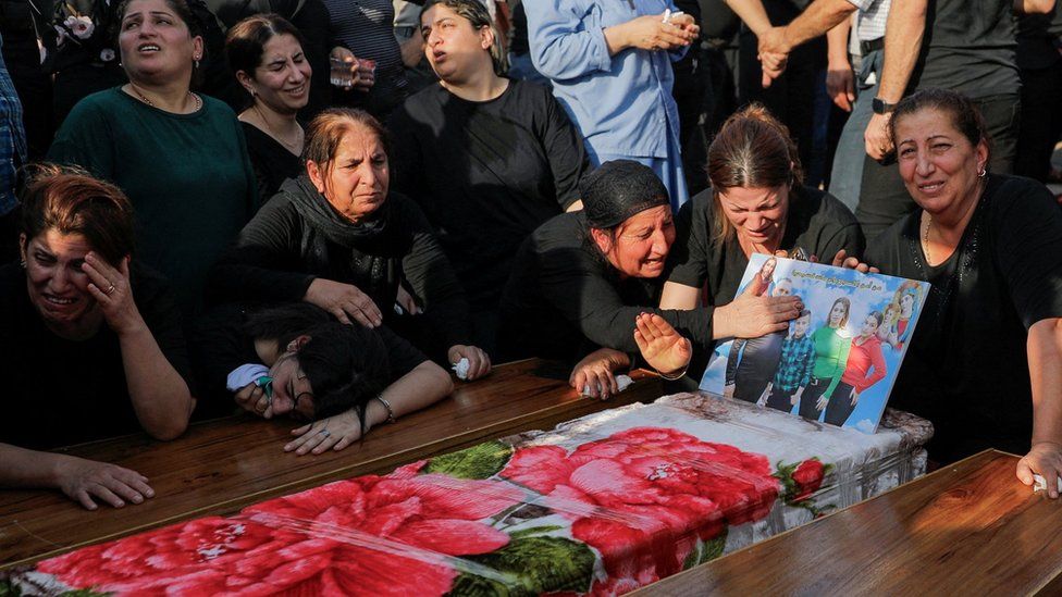 People mourning the loss of their loved ones during a deadly fire in Iraq