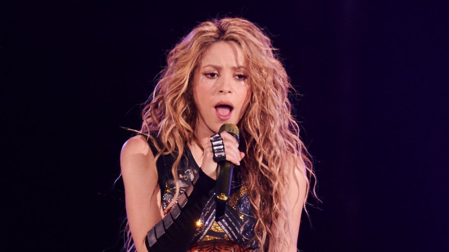Shakira wearing a black outfit while holding a mic