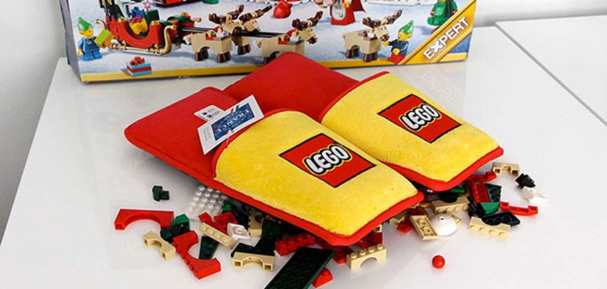 Red and yellow Anti-LEGO Slippers on top of LEGO pieces.