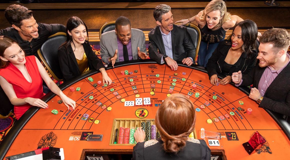 Group of people playing at Baccarat table.