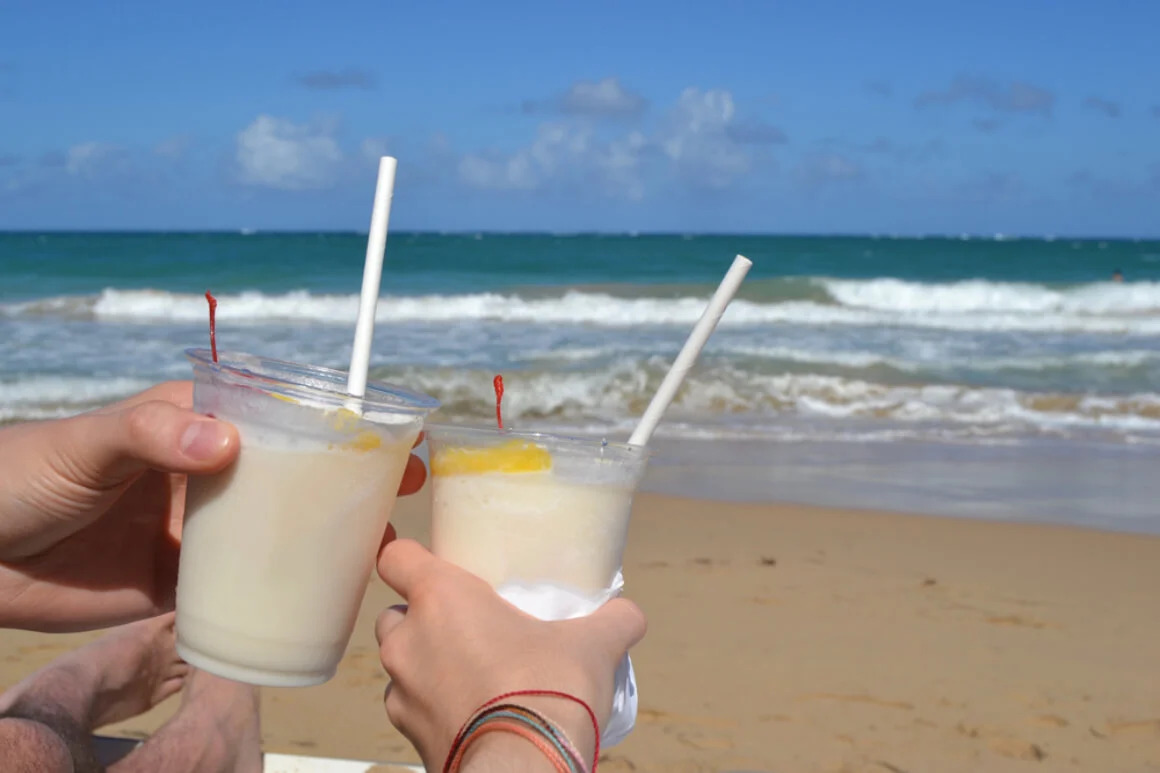 A couple with cocktails on the beach
