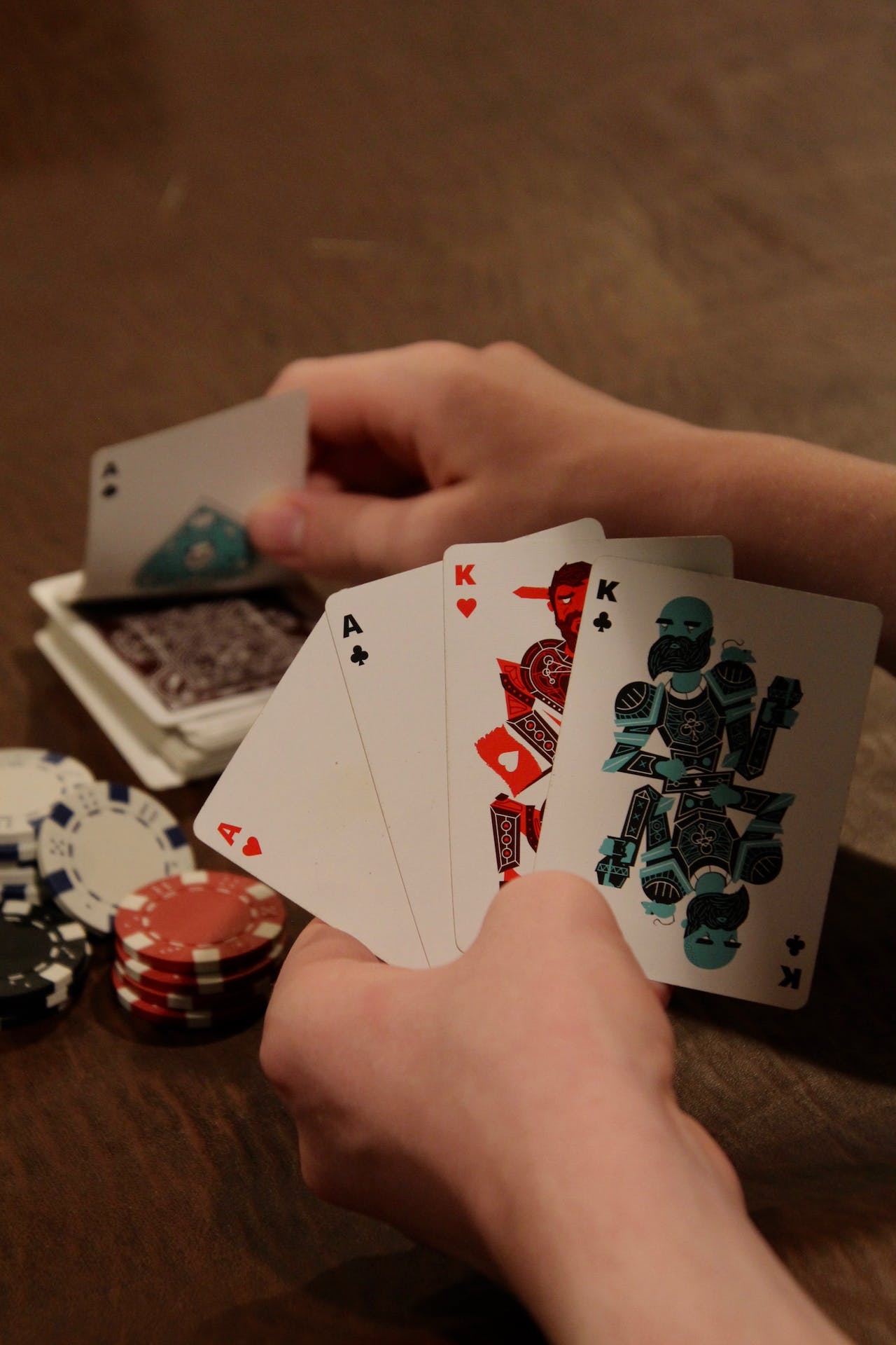 Playing cards and coins in hands